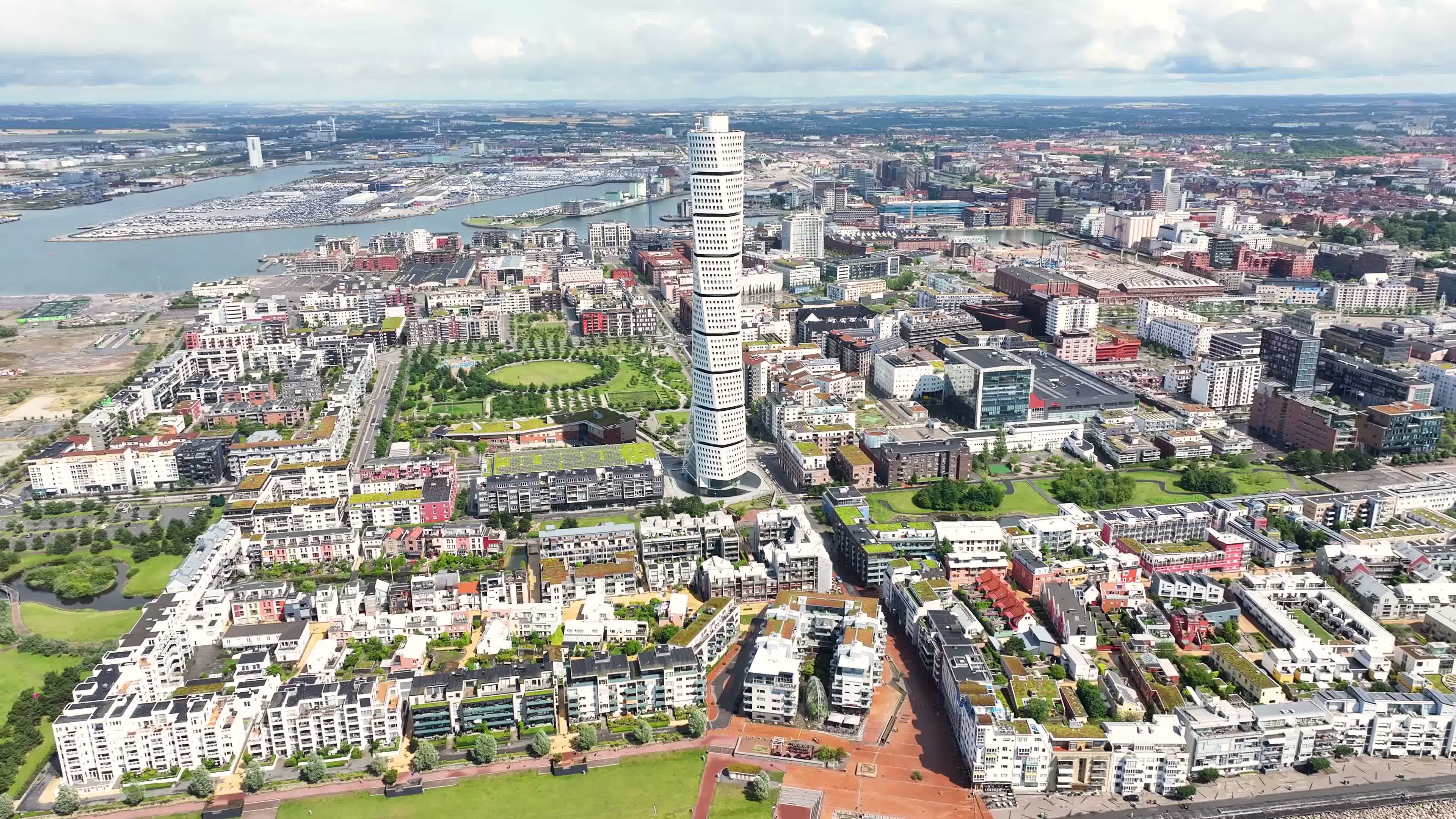 Aerial drone image of the Turning Torso skyscraper in Västra Hamnen with Malmö, Sweden, in the background, on a sunny summer day.